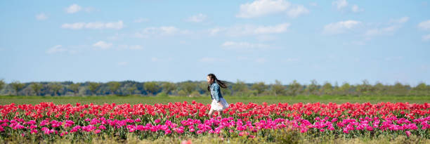 istock Girl playing in a tulip field 1311578153