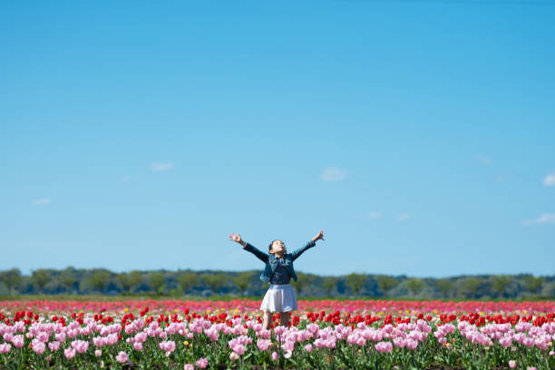 girl taking a deep breath in a flower field girl taking a deep breath in a flower field scene scented stock pictures, royalty-free photos & images