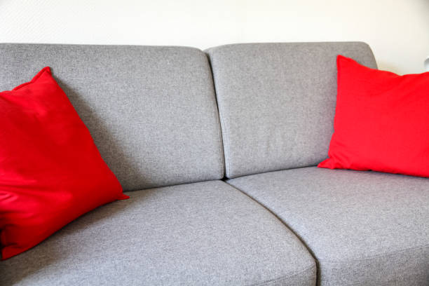 istock Grey sofa close-up view with red cushions 1311581246