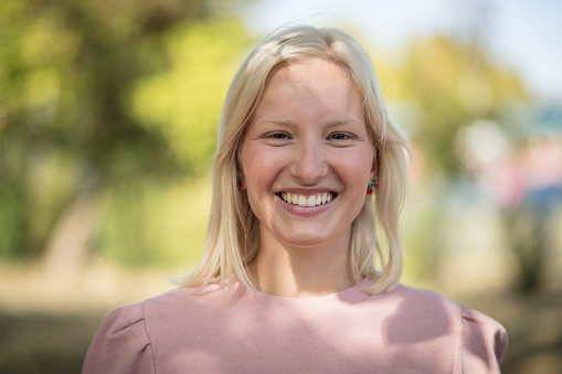 Portrait of smiling woman in the park. Looking at camera.