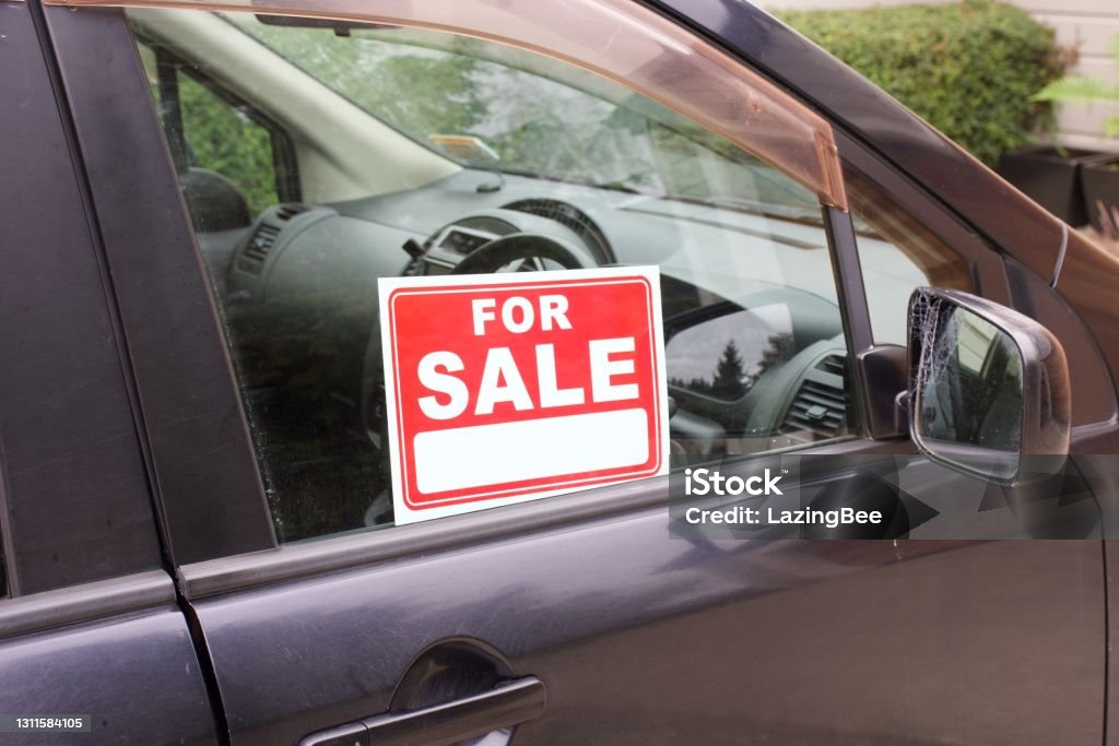 Car with For Sale Sign A For Sale sign in a car window. Used Car Selling Stock Photo