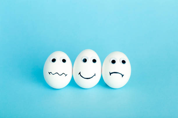 istock Fun creative food for kids. Eggs minimal concept. White funny eggs for breakfast on a colored background 1311584784