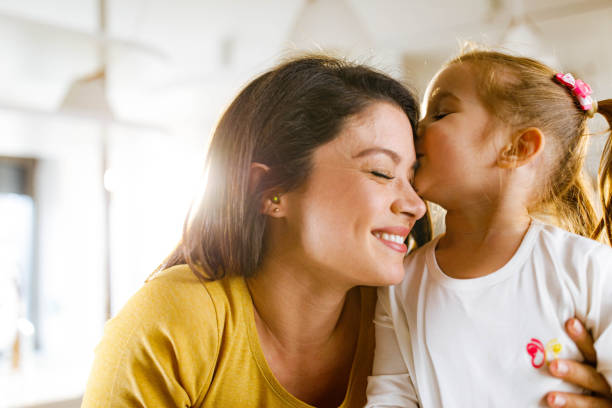 istock Affectionate daughter kissing her mother at home. 1311589064