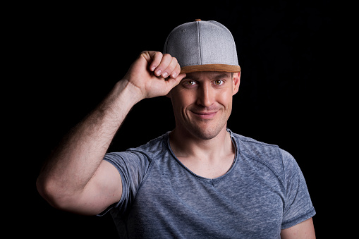 Portrait of smiling man standing against black background.