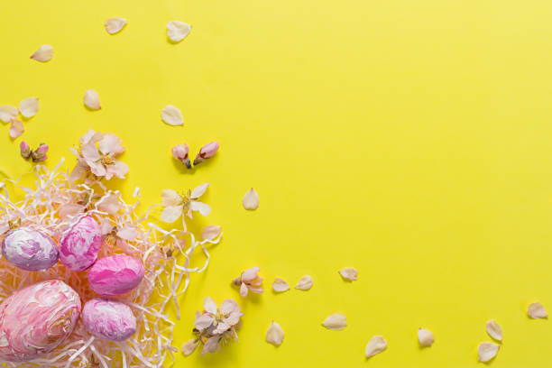 istock Easter composition of colored eggs and almond flowers on a yellow solid background. 1311590099