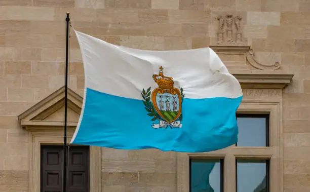 A picture of the San Marino flag waving in the air.