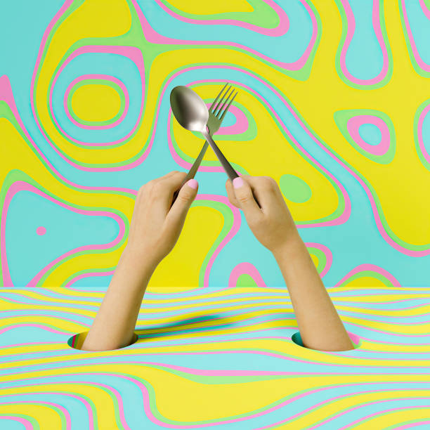 istock hands  holding a spoon and fork in cross with colorful background 1311592510
