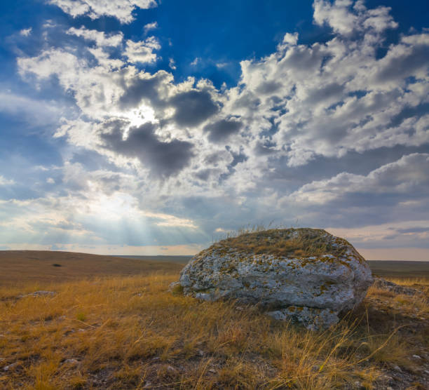huge stone among prairie under a dense cloudy sky