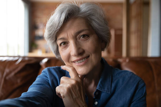 istock Attractive stylish mature hispanic lady making selfie using smartphone webcam 1311594939