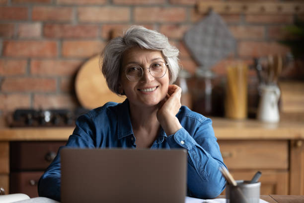 istock Happy senior hispanic female use laptop work study distantly 1311594960