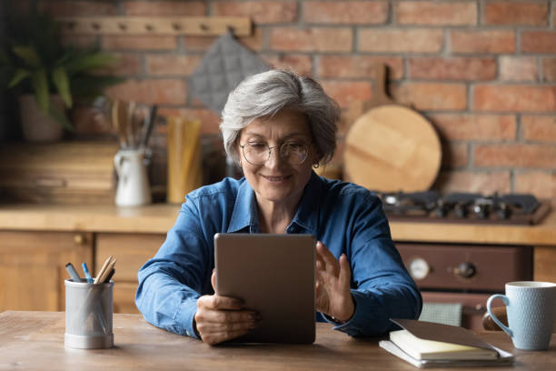 la abuela de la vejez disfruta leyendo e libro en tablet pc - senior women grandmother glasses senior adult fotografías e imágenes de stock