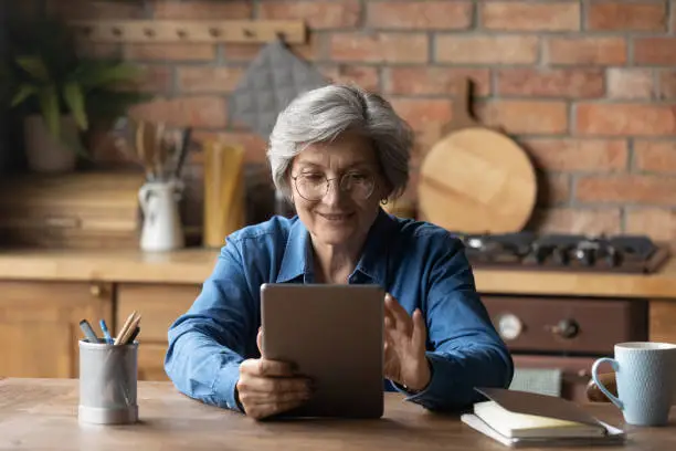 Photo of Old age grandmother enjoy reading e book on tablet pc