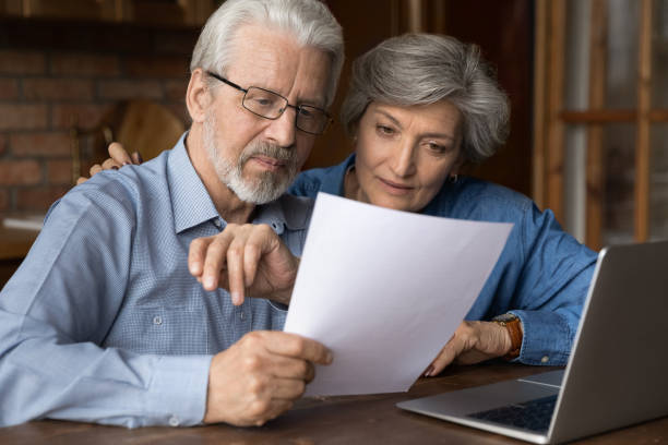 istock Old age married couple do paperwork engaged in reading document 1311594989
