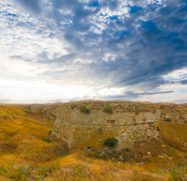 oldmedieval fortress among prairie under dense cloudy sky