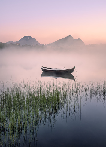 Very peaceful summer night with wooden boat and fog in Lofoten, Norway
