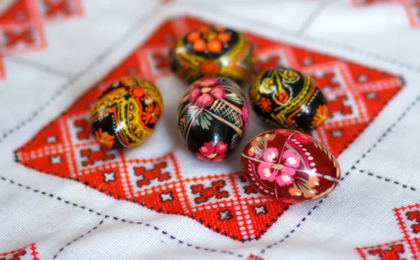 Mix of colored easter eggs with the traditional ukrainian slavic designs. Beautiful pysanka handmade - ukrainian traditional on a traditional embroidered tablecloth vyshyvanka. Selective focus Mix of colored easter eggs with the traditional ukrainian slavic designs. Beautiful pysanka handmade - ukrainian traditional on a traditional embroidered tablecloth vyshyvanka. Selective focus orthodox church easter stock pictures, royalty-free photos & images