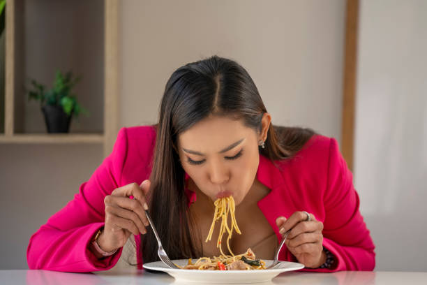 istock Hungry people eating spaghetti. A plate of pasta and a fork wildly eats pasta. 1311598087