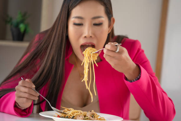 istock Hungry people eating spaghetti. A plate of pasta and a fork wildly eats pasta. 1311598103