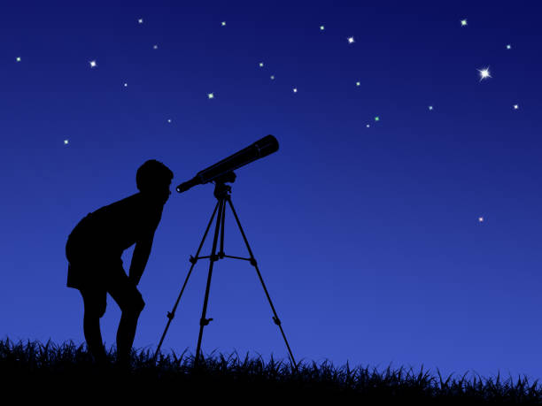 istock boy looks at the stars through a telescope 1311599655