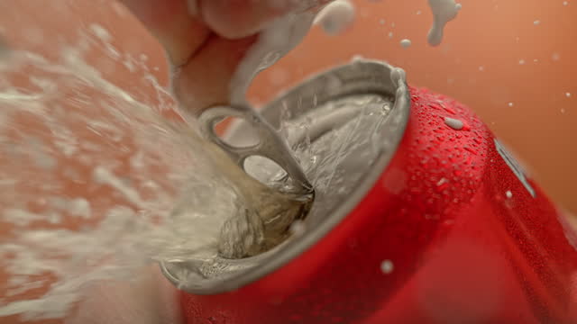 SLO MO LD Fingers opening a red can and liquid starts splashing around