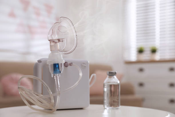 nebulizador moderno com máscara facial em mesa branca dentro de casa. equipamento de inalação - nebulizer - fotografias e filmes do acervo