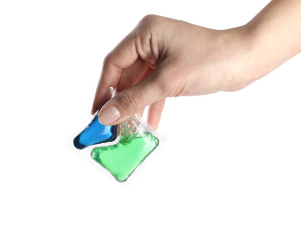 istock Woman holding laundry capsule on white background, closeup 1311601255