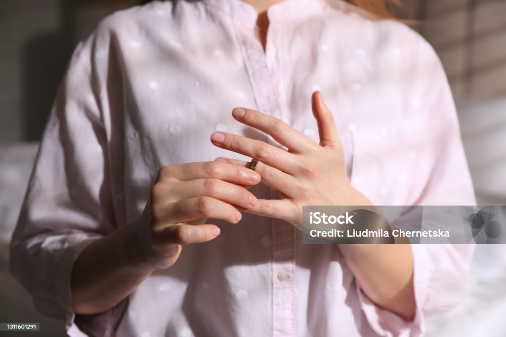 Woman taking off wedding ring indoors, closeup. Divorce concept Divorce Stock Photo
