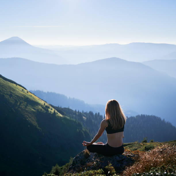 istock Brunette is meditating in Lotus pose in mountains. 1311601824