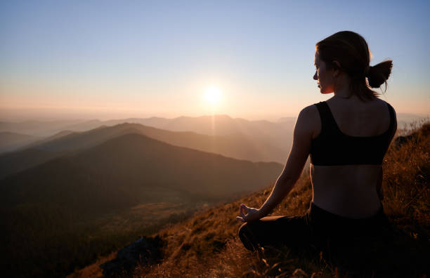 istock Woman is meditating in Lotus pose in mountains. 1311601874