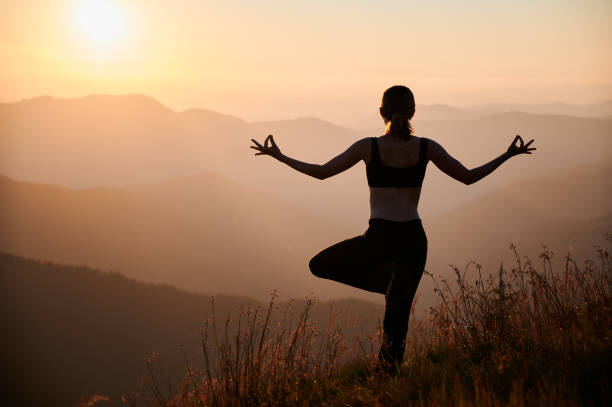 istock Sporty young woman practicing yoga during sunset in mountains. 1311601879