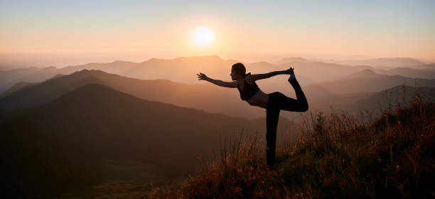 istock Fit young woman practicing yoga during sunrise in mountains. 1311601902