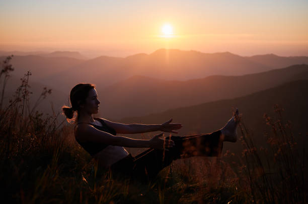 istock Sporty young woman doing exercise during sunset in mountains. 1311601903