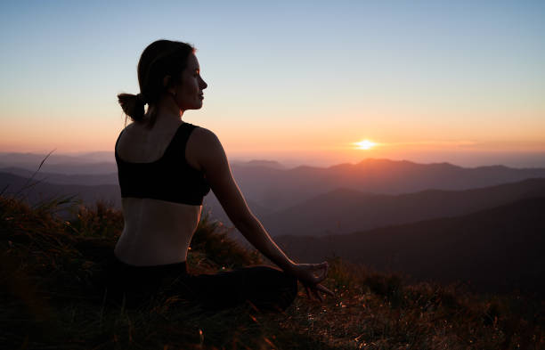 istock Woman is practicing yoga in Lotus pose in mountains. 1311601915