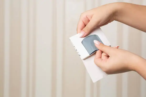 Woman hand holding charcoal absorbing sheets for oily and combined skin. Space for text