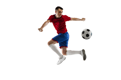 Soccer player shooting a ball on a field. About 30 years old, Caucasian male.