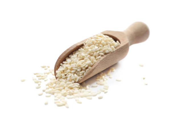 istock Wooden scoop with sesame seeds on white background 1311616300