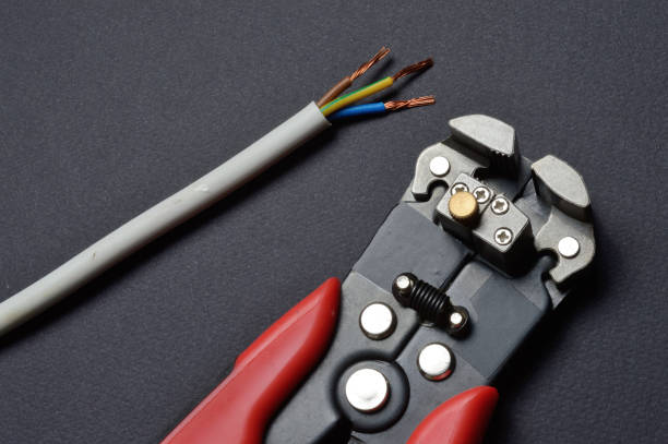 istock wire cutters and stripped three-core wire. dark background. close-up. 1311617313