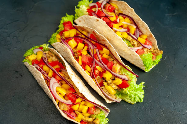 istock Mexican tacos with meat and vegetables on a stone background 1311618868