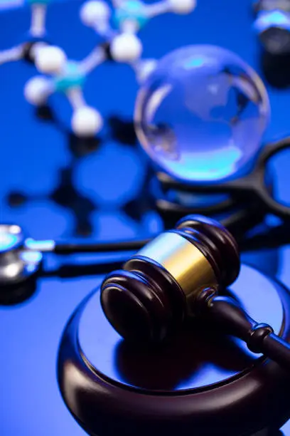 Gavel and stethoscope on the glass table. Blue light.