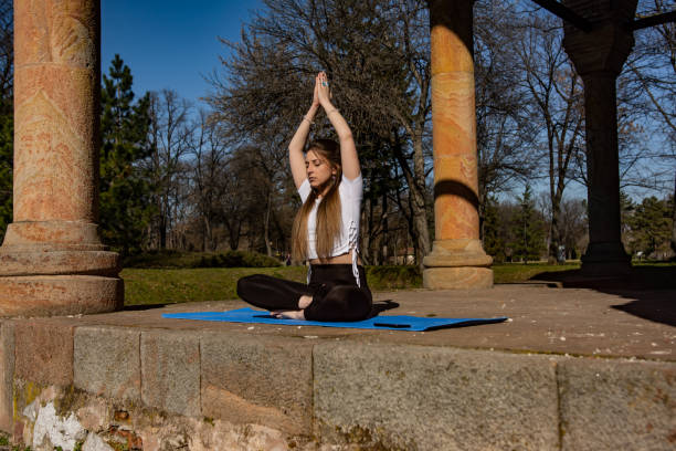 istock Beaitiful young woman practicing yoga in the park 1311622128