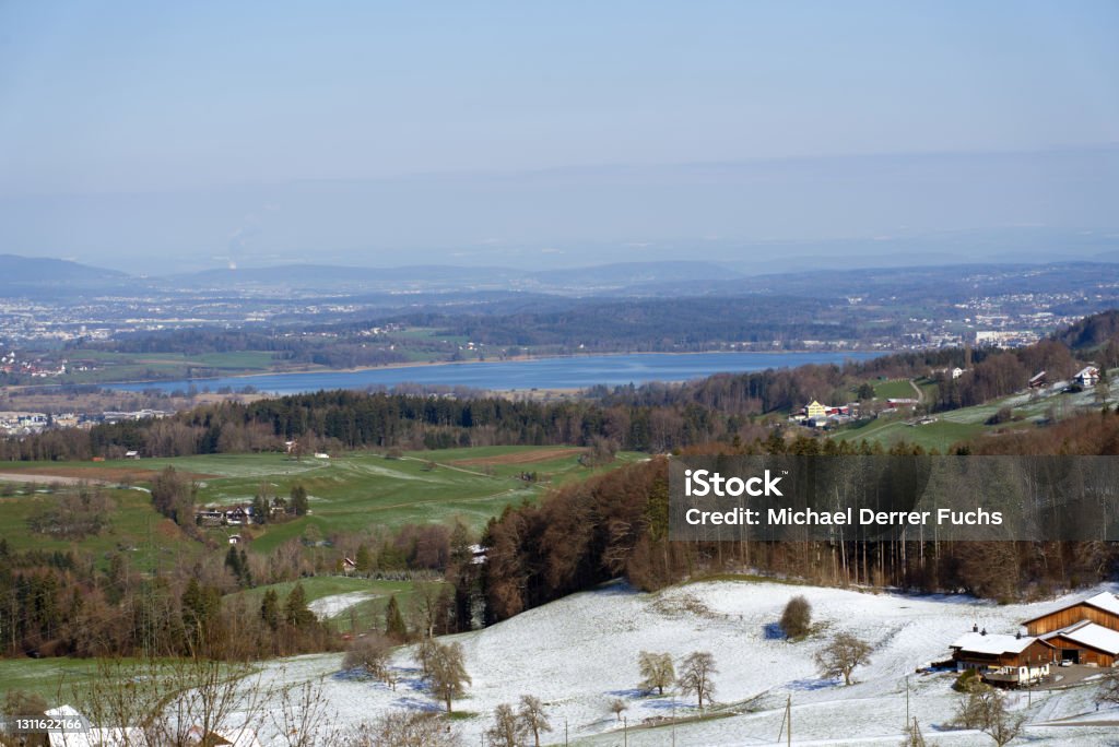 Panoramic landscape with lake Pfäffikon in the background, seen from mountain Bachtel. Photo taken April 8th, 2021, Zurich, Switzerland. Antenna - Aerial Stock Photo