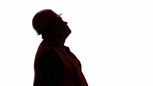 istock silhouette profile of contruction worker in hard hat looking up on white isolated background, building industry concept 1311622423