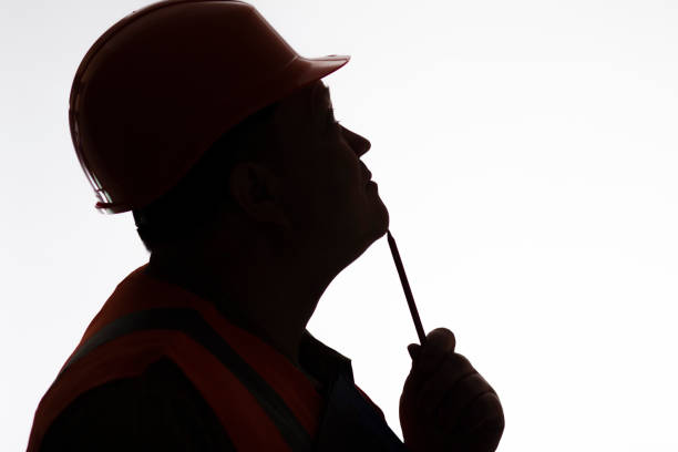 istock silhouette of thinking contruction worker profile in hard hat on white isolated background, building industry concept 1311622425
