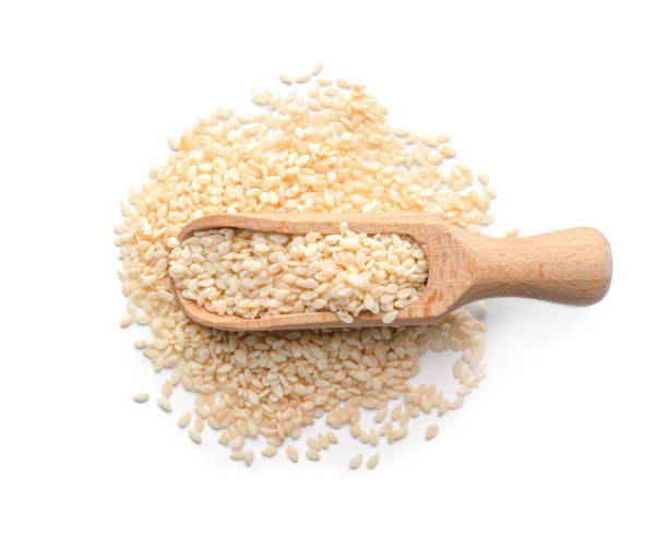 istock Wooden scoop with sesame seeds on white background, top view 1311622666