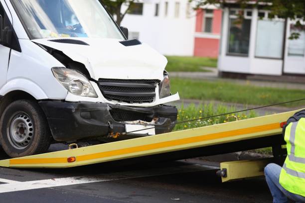 istock Wrecked white car pulling into tow truck 1311622866