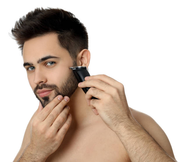 istock Handsome young man shaving with electric trimmer on white background 1311624827