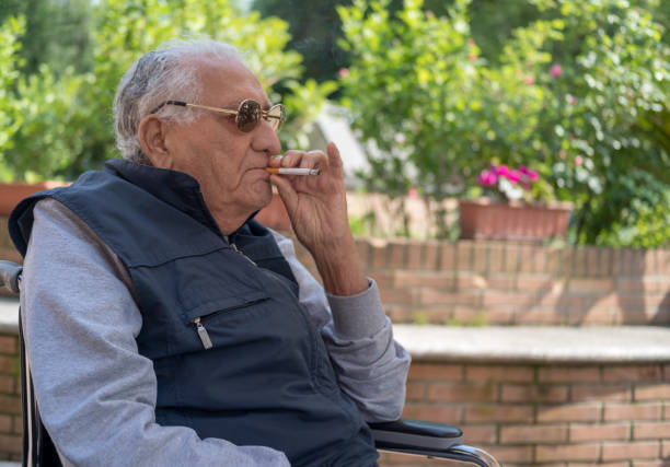 Old man smoking Senior man smoking cigarette in the garden smokers wrinkles stock pictures, royalty-free photos & images