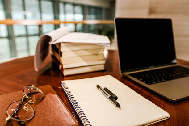 istock Close-up of laptop by books stack on table 1311627358