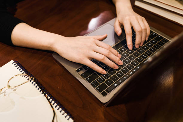 istock overhead view of  hand using laptop over Wooden table 1311627459