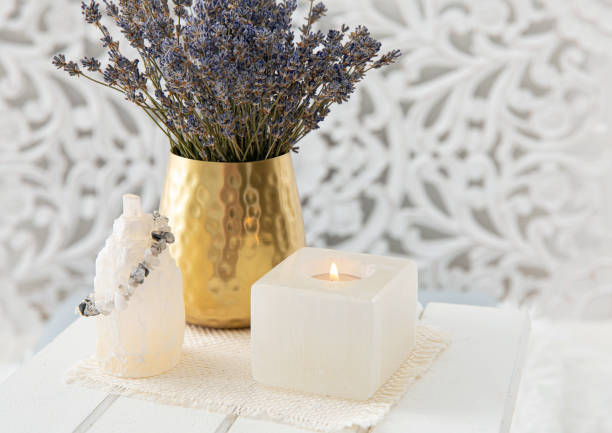 using lavender for feng shui purposes to promote happiness, wellbeing, good health in home environment. selenite crystal candle holder and tower for removing negative energy from the body and mind. - fengshui imagens e fotografias de stock